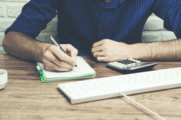 Male hands using modern computer and notepad