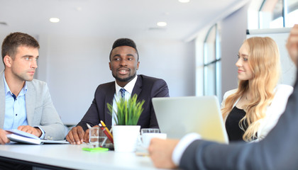 Business people in discussing something while sitting together at the table.
