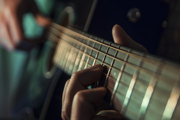 Musician man is playing the guitar on the concert