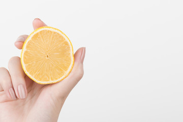  Female hands holding a lemon, orange, kiwi on a white background