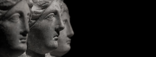 Marble ancient heads of women watching each other
