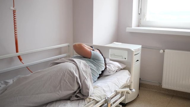 Woman mother gets out of bed in the maternity hospital room