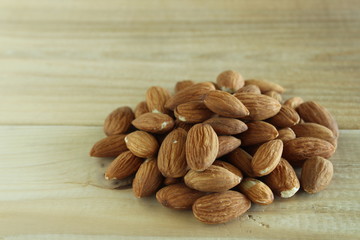 a heap of fresh walnuts on a natural wood board with writing space