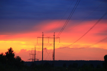 Fototapeta na wymiar Sunset with crimson clouds and high-voltage line