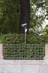 Video surveillance camera on on the post in the park.