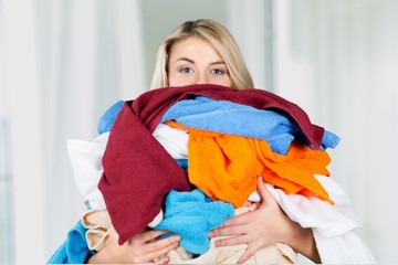 Young Tired Woman Carrying heap of different clothes