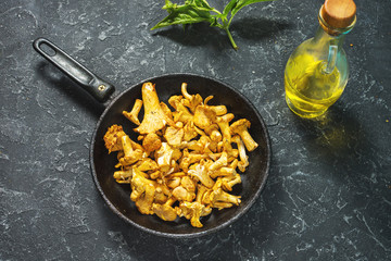 Fresh chanterelle mushrooms in a pan on a black table