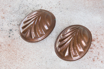 Vintage copper molds on a concrete background.