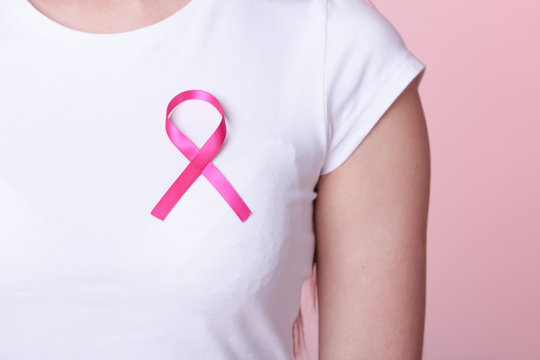 Pink ribbon on woman chest to support breast cancer cause