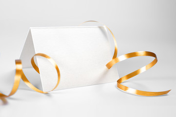 Blank folded thank you or greeting card decorated with gold ribbon 