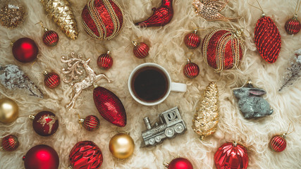 Hot tea and Christmas toys on a warm background of natural warm sheepskins. New Year 2019 composition Christmas festive still life
