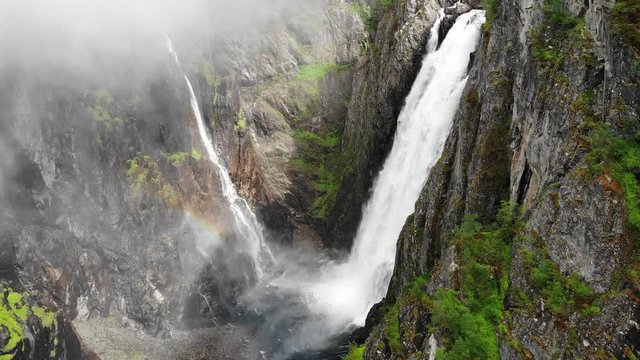 Voringsfossen waterfall, green summer mountains, Mabodalen canyon Norway. National tourist Hardangervidda route, touristroad Rv7, Eidfjord sightseeing tour.