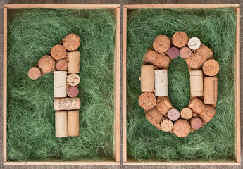 Number 10 ten made of wine corks on green background in wooden box