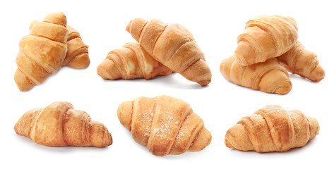 Set with fresh tasty croissants on white background