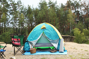Camping tent and accessories in wilderness on summer day