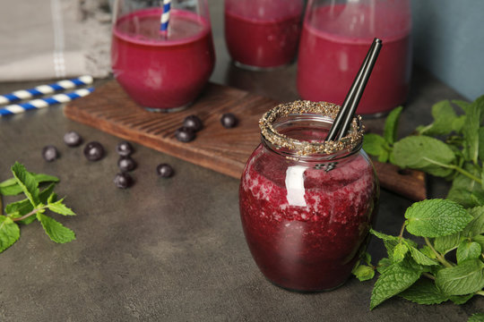 Composition with jar of acai juice on dark table