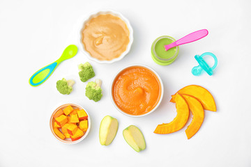Flat lay composition with bowls of healthy baby food on white background