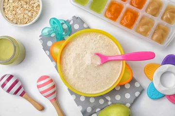 Poster Flat lay composition with bowl of healthy baby food on white background © New Africa