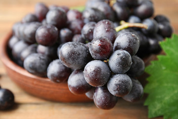 Fresh ripe juicy grapes in bowl on table, closeup
