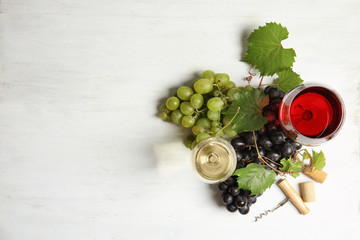 Flat lay composition with fresh ripe juicy grapes and space for text on wooden background