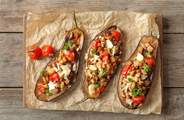 Flat lay composition with stuffed eggplants on wooden table