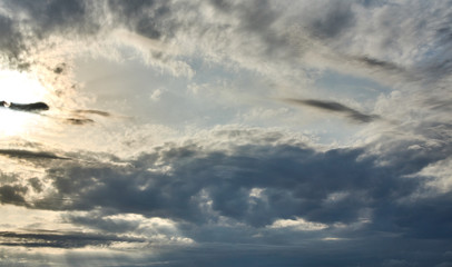 Beautiful sunset sky background with clouds and sunbeams