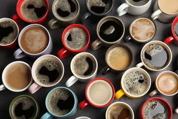 Many cups with tasty aromatic coffee on table, flat lay
