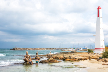 Strand von Can Picafort, Mallorca mit Ausrichtungsturm, Badegästen und Skulpturen