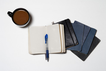 Isolated worn notebook with pen and coffee