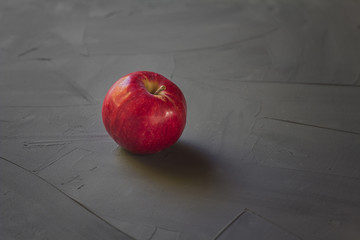 bright red apple isolated on grey and black background