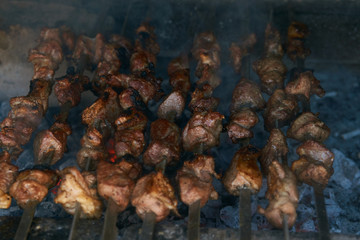 Roasted meat cooked at barbecue. Grilled kebab cooking on metal skewer. BBQ fresh beef meat chop slices. Traditional eastern dish, shish kebab. Grill on charcoal and flame, picnic, street food