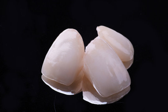 dental ceramic veneers and crowns isolated with mirror background.