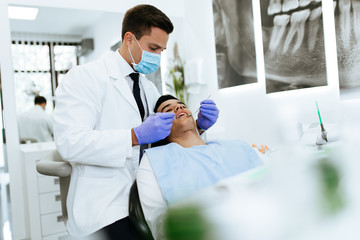 Young attractive man receiving a dental treatment. Close up shot.