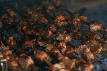 Roasted meat cooked at barbecue. Grilled kebab cooking on metal skewer. BBQ fresh beef meat chop slices. Traditional eastern dish, shish kebab. Grill on charcoal and flame, picnic, street food