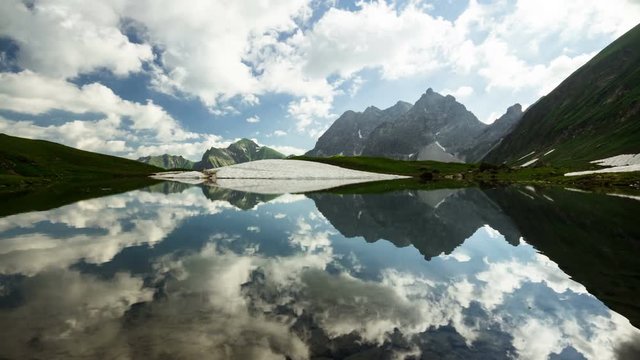 Time lapse symetrical reflection of clouds and sunrays in lake Eissee in Allgau Alps near Oberstdorf Bavaria Germany travel hiking mountains