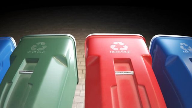 Colorful plastic garbage bins stacked in a row against a brick wall in a loop.