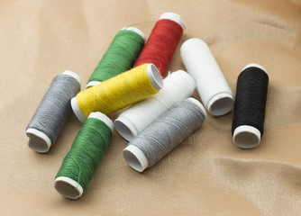 Several bobbins on a background of brown cloth