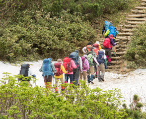 一列になって登山に出発する人々