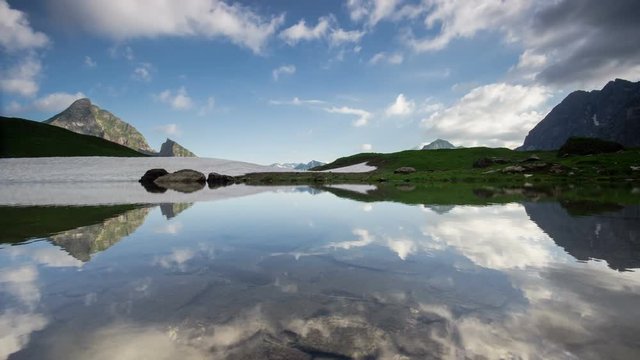Time lapse symmetrical reflection of clouds and sunrays in lake Eissee in Allgau Alps near Oberstdorf Bavaria Germany travel hiking mountains