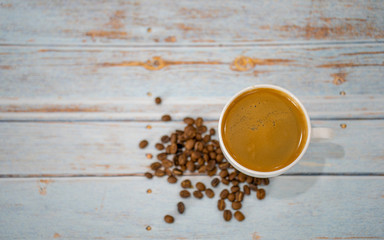 Cup of fresh hot coffee on blue wooden background, top view, coffee time