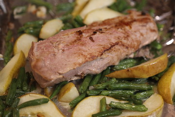 Roast port tenderloin plated with roasted pears, broccoli, and red onions
