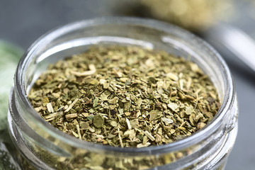 Dried leaves of yerba mate tea, a traditional tea in South-America, photographed in glass jar on slate (Selective Focus, Focus one third into the tea leaves)