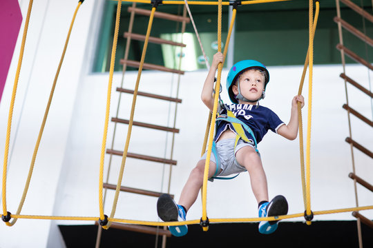 Young Boy Taking The Challenge At The Indoor High Rope Course