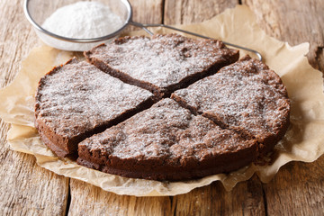 home-made fresh Swedish dessert: kladdkaka chocolate sticky cake with powdered sugar close-up....