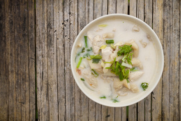 Chicken Coconut Soup (Tom Kha Gai) in cup on a bamboo floor