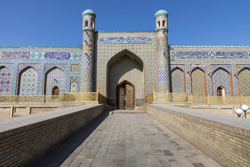 Fototapeta na wymiar Khan's palace in Kokand. Uzbekistan. Ancient palace with facades of colored mosaic. The main entrance is with minarets.