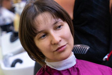 Fototapeta na wymiar Beautiful young woman in hairstyle salon getting bob haircut