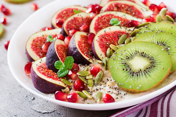Delicious and healthy oatmeal with figs, kiwi and pomegranate. Healthy breakfast. Fitness food. Proper nutrition.