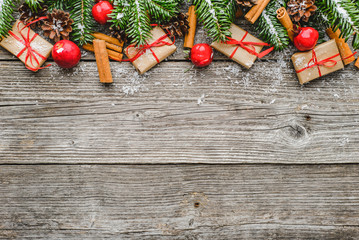 Christmas gift boxes, border with fir tree, present boxes and snow on wooden background, flat lay...