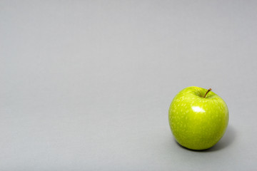 Green fresh apple on grey background